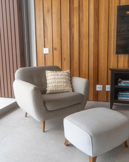 Poltrona decorada com almofada quadrada feita a mão em tear com lã merino cor cru natural.